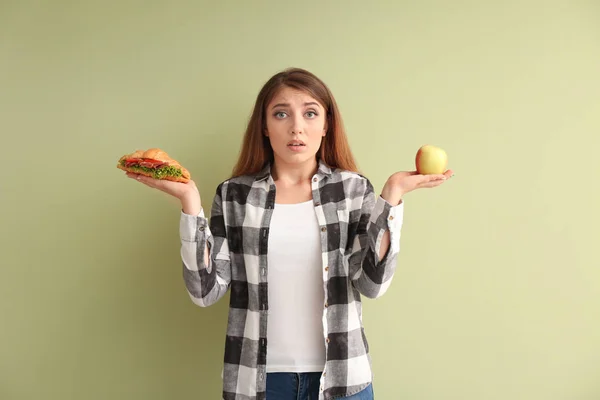 Mujer Joven Eligiendo Entre Croissant Manzana Sobre Fondo Color —  Fotos de Stock