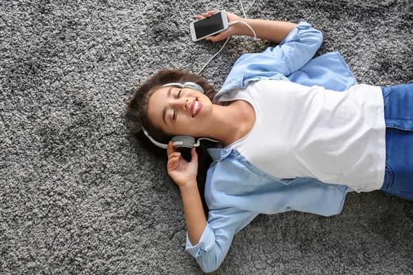 Hermosa Mujer Joven Escuchando Música Mientras Está Acostada Alfombra Casa —  Fotos de Stock