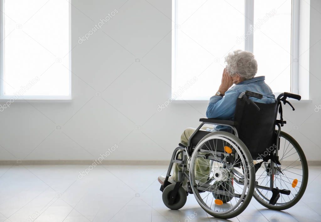 Lonely senior woman in wheelchair indoors