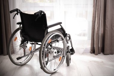 Oda penceresinde yakınındaki boş modern tekerlekli sandalye