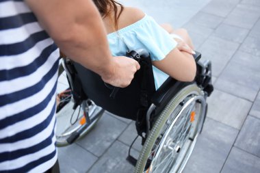 Genç Kadın kocasıyla açık havada yürüyüş tekerlekli sandalyede