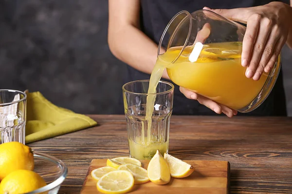 Mujer Vertiendo Jugo Limón Fresco Del Frasco Vaso Sobre Mesa —  Fotos de Stock