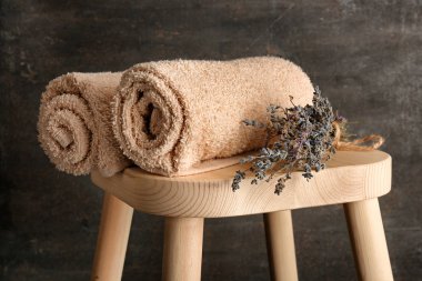 Temiz yumuşak havlu ve hafif ahşap dışkı üzerinde kuru lavanta