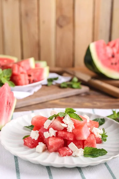 Plate with delicious watermelon salad on table