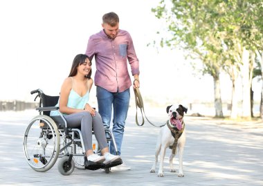 Tekerlekli sandalye ile onun kocası ve hizmet köpek açık havada Genç kadın