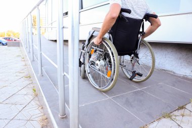 Tekerlekli sandalyedeki genç adam rampada.