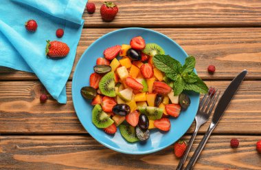 Lezzetli meyve salatası ve ahşap masa nane ile plaka
