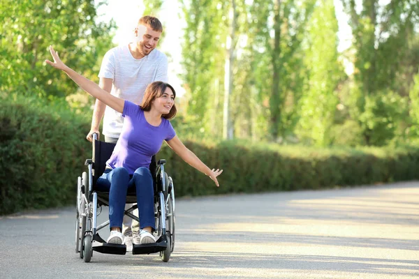 Szczęśliwa Młoda Kobieta Wózku Inwalidzkim Wraz Mężem Zewnątrz — Zdjęcie stockowe
