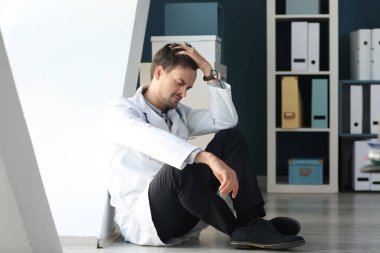 Yorgun doktor ofisinde katta oturan