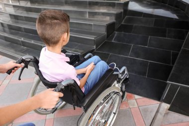 Genç kız ve erkek kardeşi tekerlekli sandalyeye mahkum merdiven açık havada yakınındaki