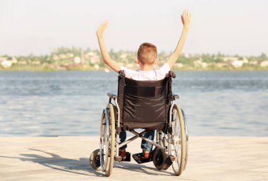 Tekerlekli sandalyeye mahkum Nehri yakınında mutlu çocuk