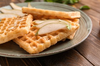 Plaka üzerinde armut dilimleri ile lezzetli waffle