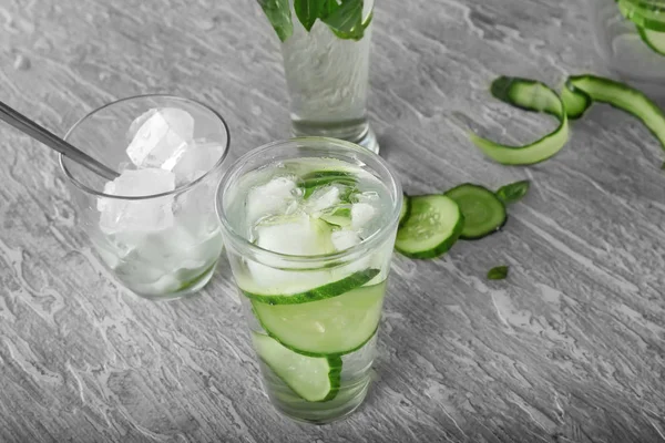 Glass of fresh cucumber water on light table