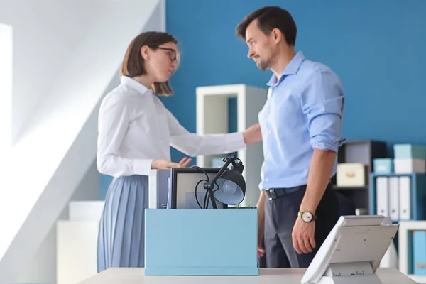 Woman calming fired colleague in office