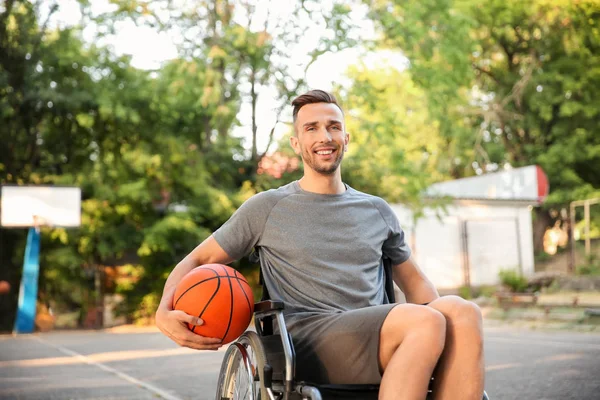 屋外に車椅子に座ってボールを持つスポーティな若者 — ストック写真