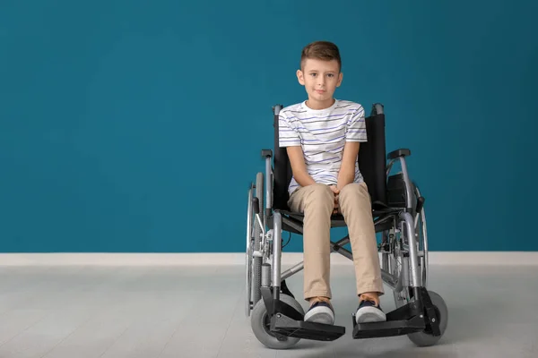 色の壁に車椅子の少年 — ストック写真