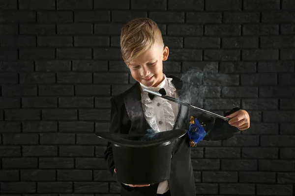 Lindo Mago Mostrando Truco Con Sombrero Contra Pared Ladrillo Oscuro — Foto de Stock