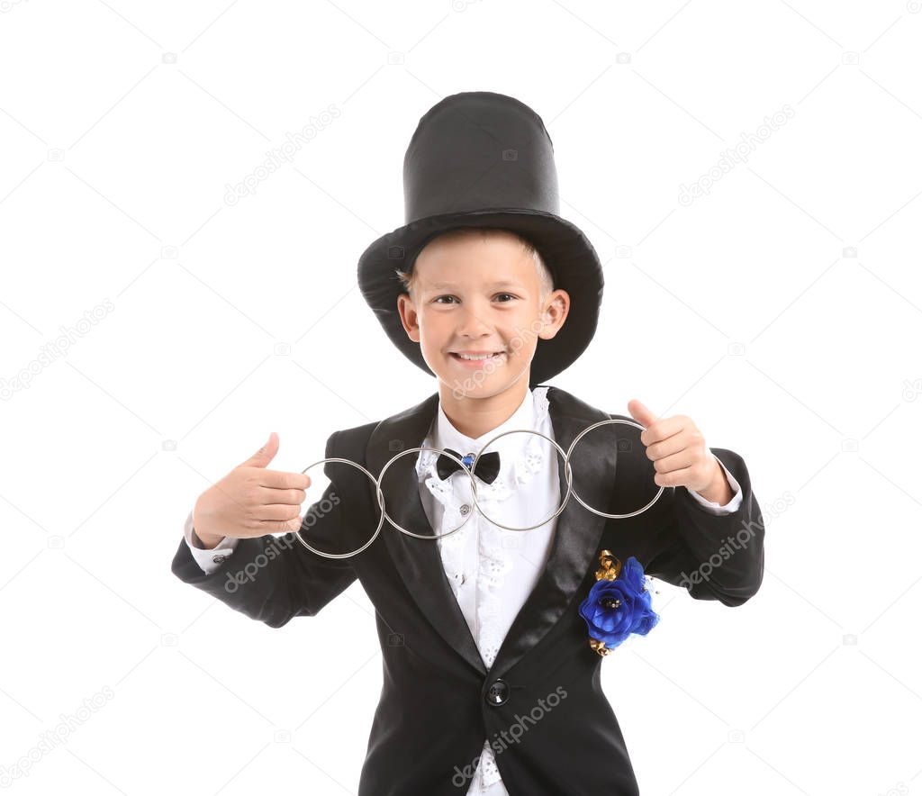 Cute little magician showing trick with rings on white background