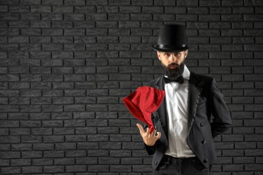 Hileler karanlık duvara karşı gösterilen sihirbaz