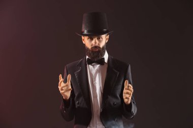 Koyu renk arka plan üzerinde erkek sihirbaz