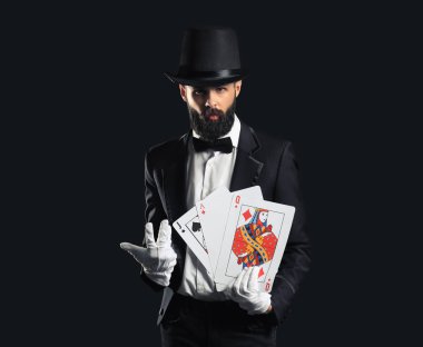 Koyu arkaplanda kartları olan sihirbaz