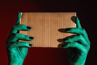 Boş kart koyu arka plan üzerinde tutan canavar