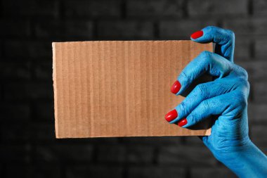 Boş kart koyu arka plan üzerinde tutan canavar