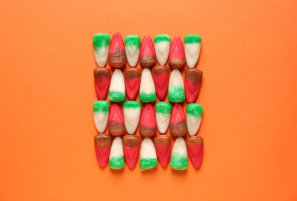 Tasty candies for Halloween party on color background