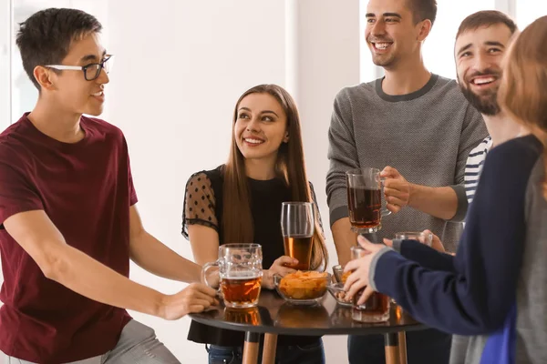 Group of cheerful friends drinking beer in bar