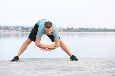 Sportif genç adam eğitim açık havada Nehri yakınında
