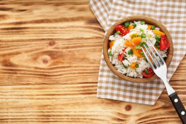 Lezzetli haşlanmış pirinç ve sebze ahşap masa üzerinde kase