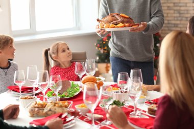 Mutlu bir aile evde Noel yemeği yiyor.