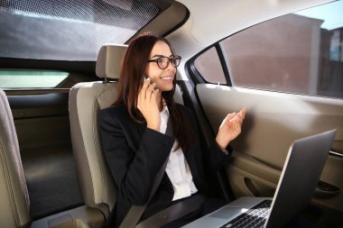 Cep telefonu arabada konuşurken genç iş kadını