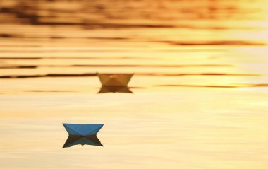Origami tekneler gün batımında su yüzeyinde