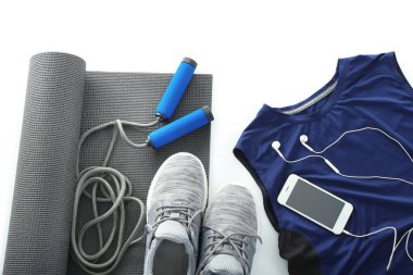 Yoga mat, telefon, spor ve beyaz arka plan üzerinde ip atlama ile kompozisyon