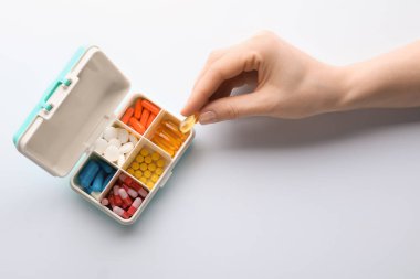 Kadın alarak hap beyaz arka plan üzerinde Plastik Konteyner üzerinden