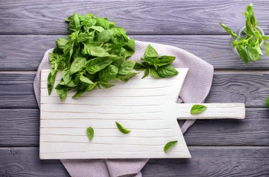 Kesme tahtası ahşap masa üzerinde taze yeşil fesleğen ile