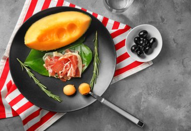 Plaka ile lezzetli kavun ve prosciutto masada, üstten görünüm