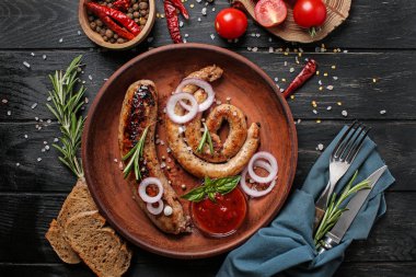 Lezzetli kızarmış sosis ve domates sosu ahşap masa üzerinde plaka