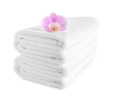 Beyaz arka plan üzerinde çiçek ile temiz yumuşak havlu yığını