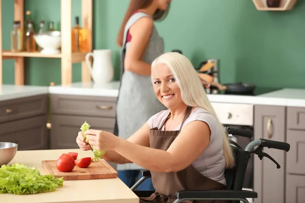 自宅で娘と一緒に料理の車椅子熟女 — ストック写真
