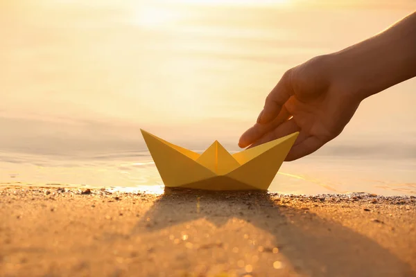 Γυναίκα Βάζει Origami Σκάφος Στην Επιφάνεια Νερού Κοντά Τράπεζα — Φωτογραφία Αρχείου