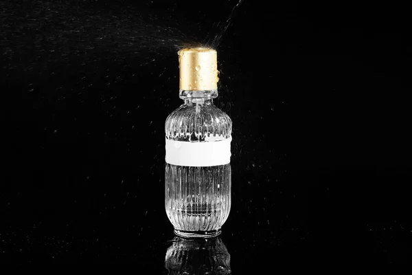 Gieten Van Water Fles Met Parfum Tegen Zwarte Achtergrond — Stockfoto