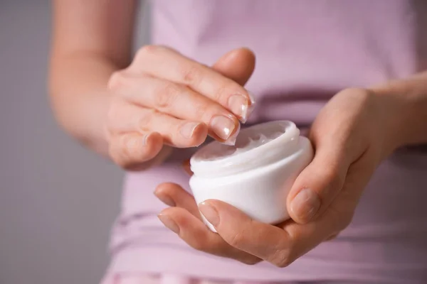 Mujer Aplicando Crema Corporal Sobre Fondo Gris Primer Plano —  Fotos de Stock