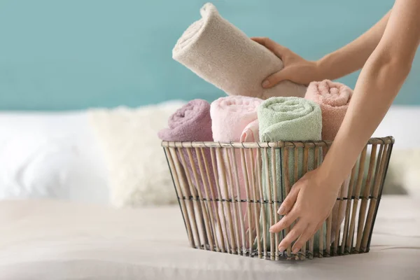 Mujer Poniendo Toallas Limpias Enrolladas Cesta Cama — Foto de Stock