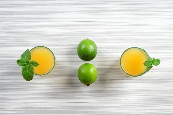 Flat lay composition with fresh citrus juice on white wooden table