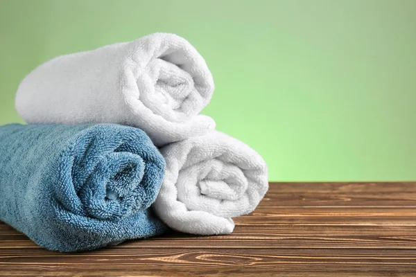 Rolled Clean Towels Wooden Table Color Background — Stock Photo, Image