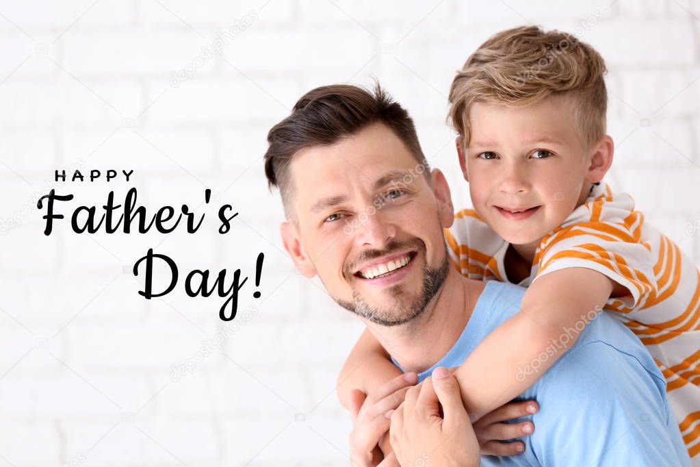 Little boy with his dad on light background. Happy Father's Day celebration