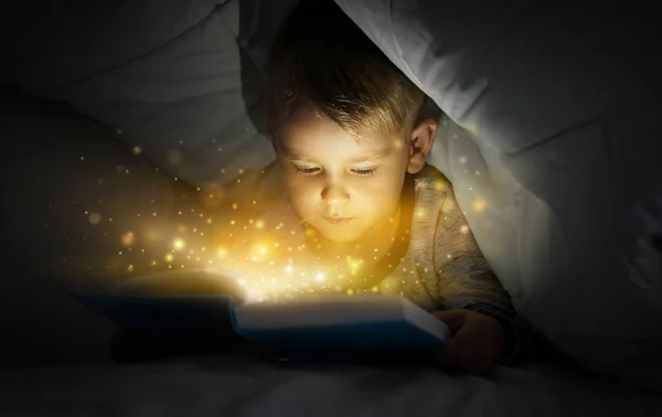 Милый Мальчик Читает Волшебную Книгу Постели Одеялом — стоковое фото