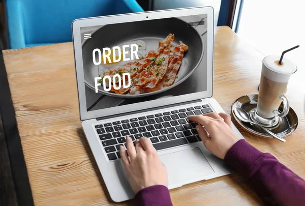Woman using laptop to order food delivery online